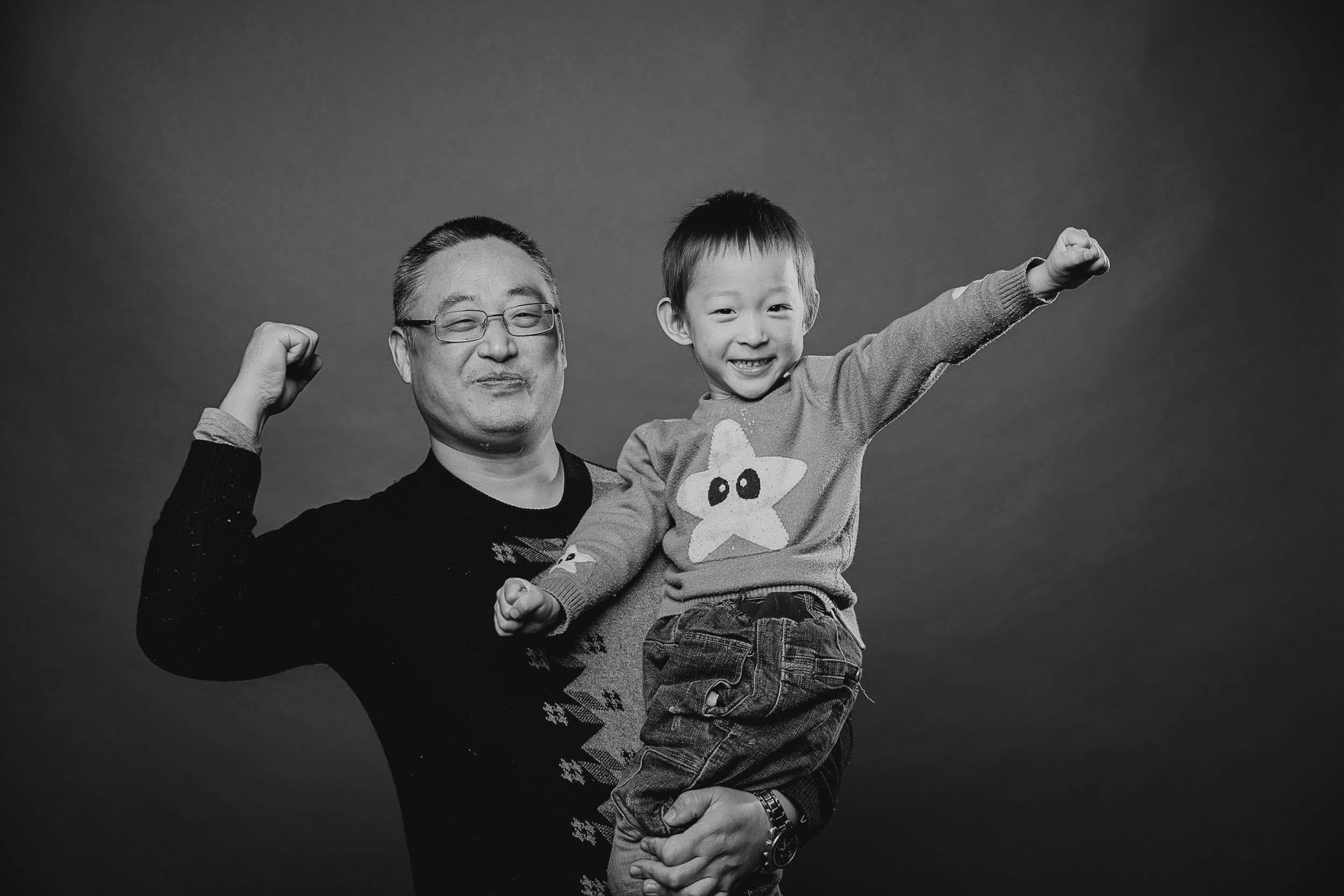 A father and his son throw their hands in the air as they pose for a photo at last year's Help Portrait event